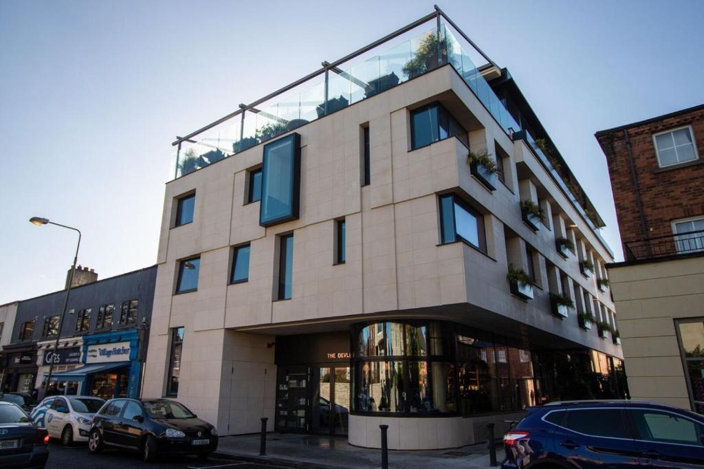 un gran edificio con coches estacionados frente a él en The Devlin Dublin en Dublín