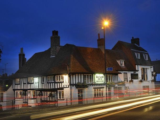 een groot gebouw op een straat met een straatlicht bij The Lamb Inn in Eastbourne