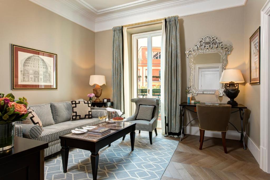 a living room with a couch and a table at Rocco Forte Hotel De La Ville in Rome