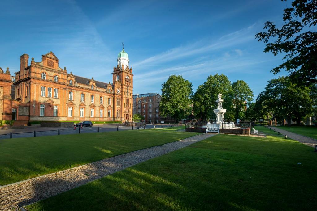 a large building with a clock tower and a park at Clayton Hotel Ballsbridge in Dublin