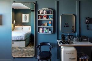 1 dormitorio con espejo, cama y escritorio en The Devlin Dublin en Dublín