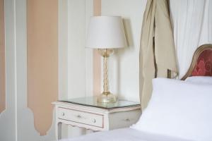 a table with a lamp on it next to a bed at Hotel Cipriani, A Belmond Hotel, Venice in Venice