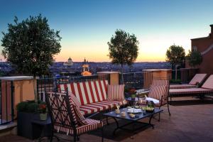 een patio met stoelen en een tafel op een balkon bij Rocco Forte Hotel De La Ville in Rome