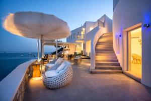 a balcony of a house with a couch and stairs at Blue Sand Boutique Hotel & Suites in Agali