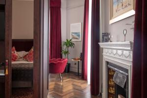 a living room with a fireplace and a red chair at The Wilder in Dublin