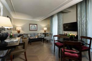 a living room with a couch and a table at Rocco Forte Hotel De La Ville in Rome