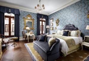 um quarto com paredes azuis, uma cama e um sofá em The Gritti Palace, a Luxury Collection Hotel, Venice em Veneza