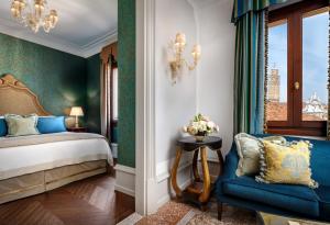 um quarto com uma cama e uma cadeira azul em The Gritti Palace, a Luxury Collection Hotel, Venice em Veneza