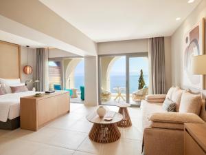 um quarto de hotel com uma cama king-size e uma sala de estar em MarBella, Mar-Bella Collection em Agios Ioannis Peristerion