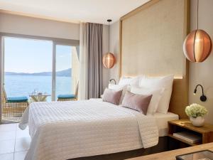 a bedroom with a bed with a view of the ocean at MarBella, Mar-Bella Collection in Agios Ioannis Peristeron