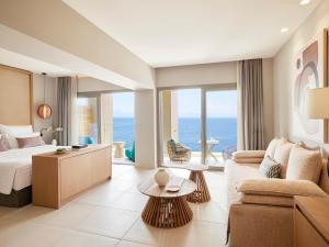 Habitación de hotel con cama y sofá en MarBella, Mar-Bella Collection en Agios Ioannis Peristerion