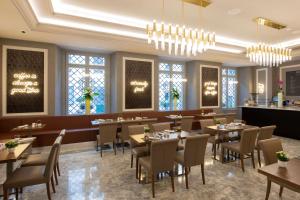 a dining room with tables and chairs and windows at Aleph Rome Hotel, Curio Collection By Hilton in Rome