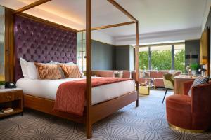 a bedroom with a canopy bed and a living room at The Fitzwilliam Hotel in Dublin