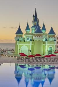 a resort with red umbrellas in front of a building at Bahia Principe Fantasia Tenerife - All Inclusive in San Miguel de Abona