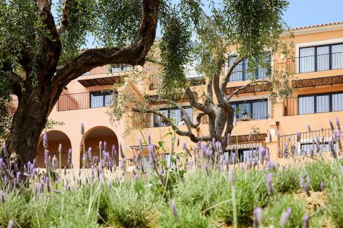 a building with purple flowers in front of a building at Nido, Mar-Bella Collection in Agios Ioannis Peristeron