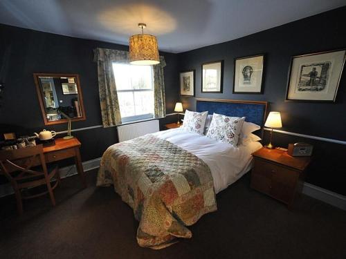 a bedroom with a bed and a desk and a window at The Lamb Inn in Eastbourne