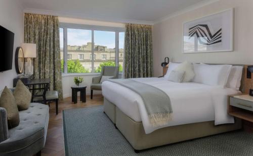 a bedroom with a large white bed and a large window at Conrad Dublin in Dublin