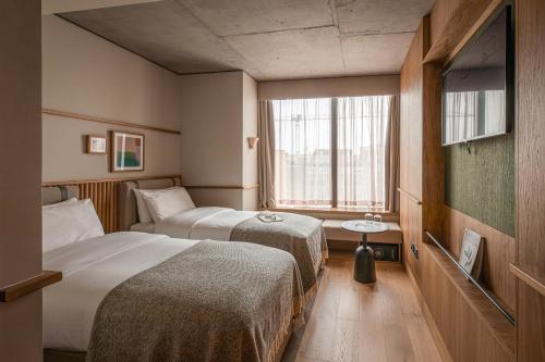 um quarto de hotel com duas camas e uma janela em Wren Urban Nest em Dublin