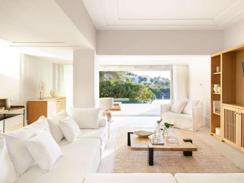 a living room with a white couch and a table at Corfu Imperial, Grecotel Beach Luxe Resort in Kommeno