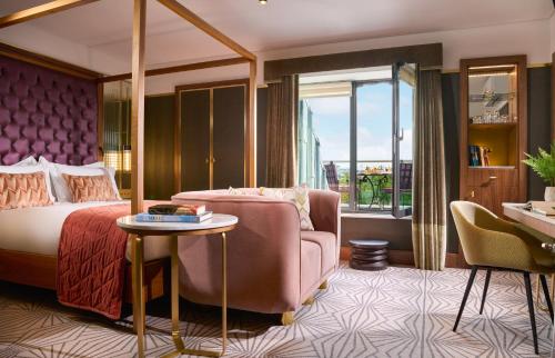 una camera con letto, sedia e tavolo di The Fitzwilliam Hotel a Dublino