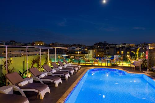 a hotel swimming pool with lounge chairs on a roof at Aleph Rome Hotel, Curio Collection By Hilton in Rome