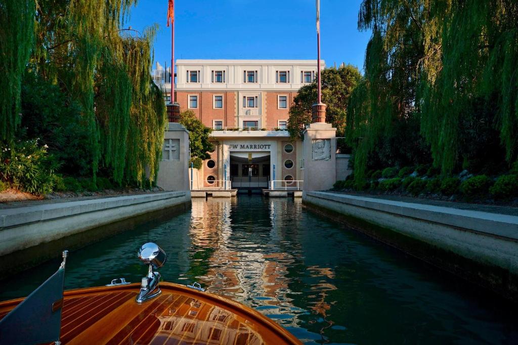 un barco en un canal frente a un edificio en JW Marriott Venice Resort & Spa en Venecia