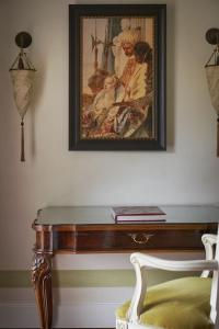 um quadro pendurado numa parede com uma mesa em Hotel Cipriani, A Belmond Hotel, Venice em Veneza