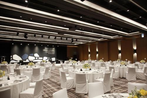 a banquet hall with white tables and white chairs at PARK ROCHE Resort & Wellness in Jeongseon