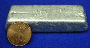 A bar of indium metal and a penny.