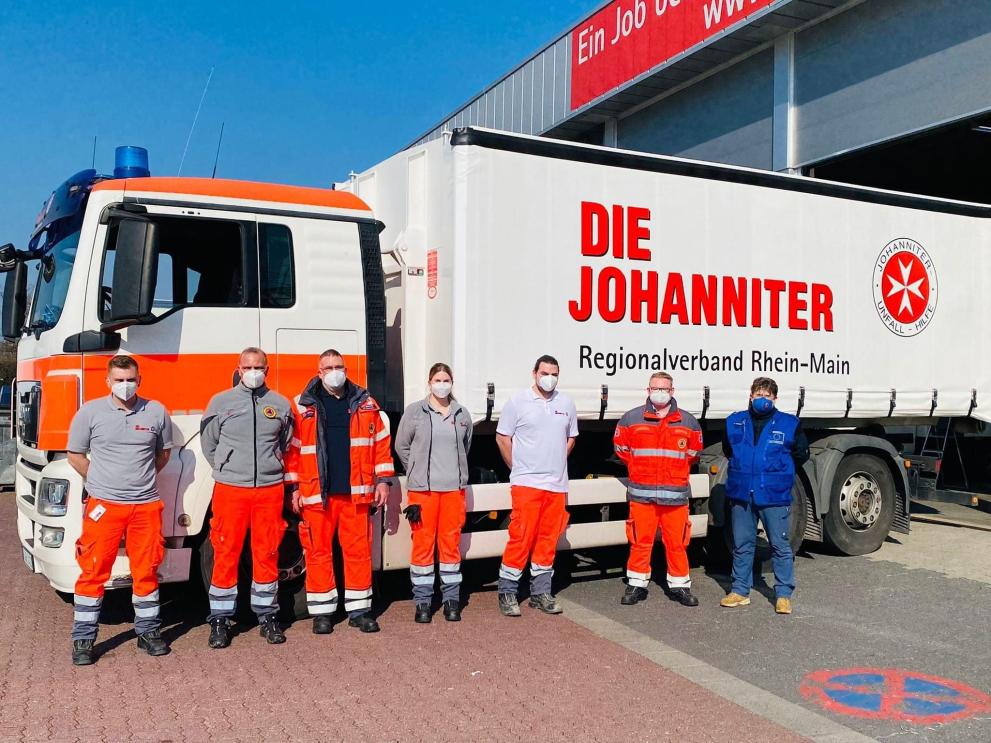 Group of people in front of a truck.