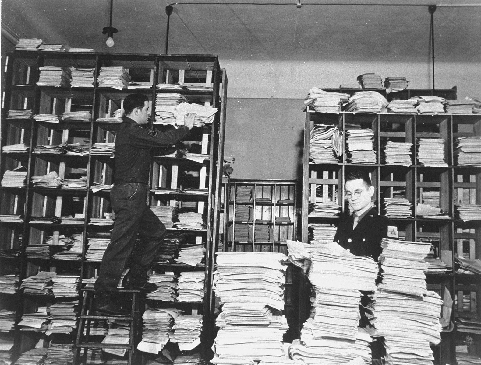 American army staffers organize stacks of German documents that were collected by war crimes investigators as evidence for the International Military Tribunal trial of war criminals at Nuremberg.