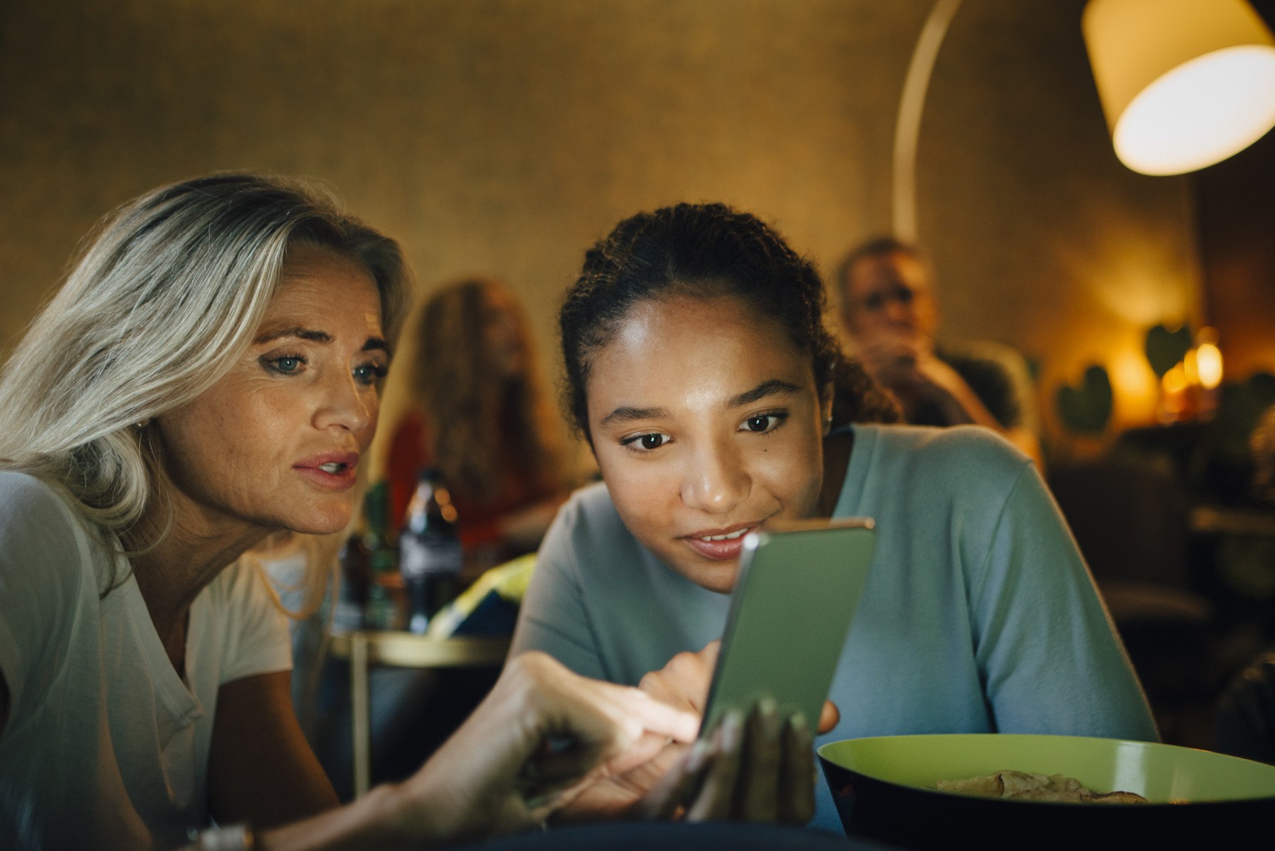 Lady and girl looking at a mobile phone