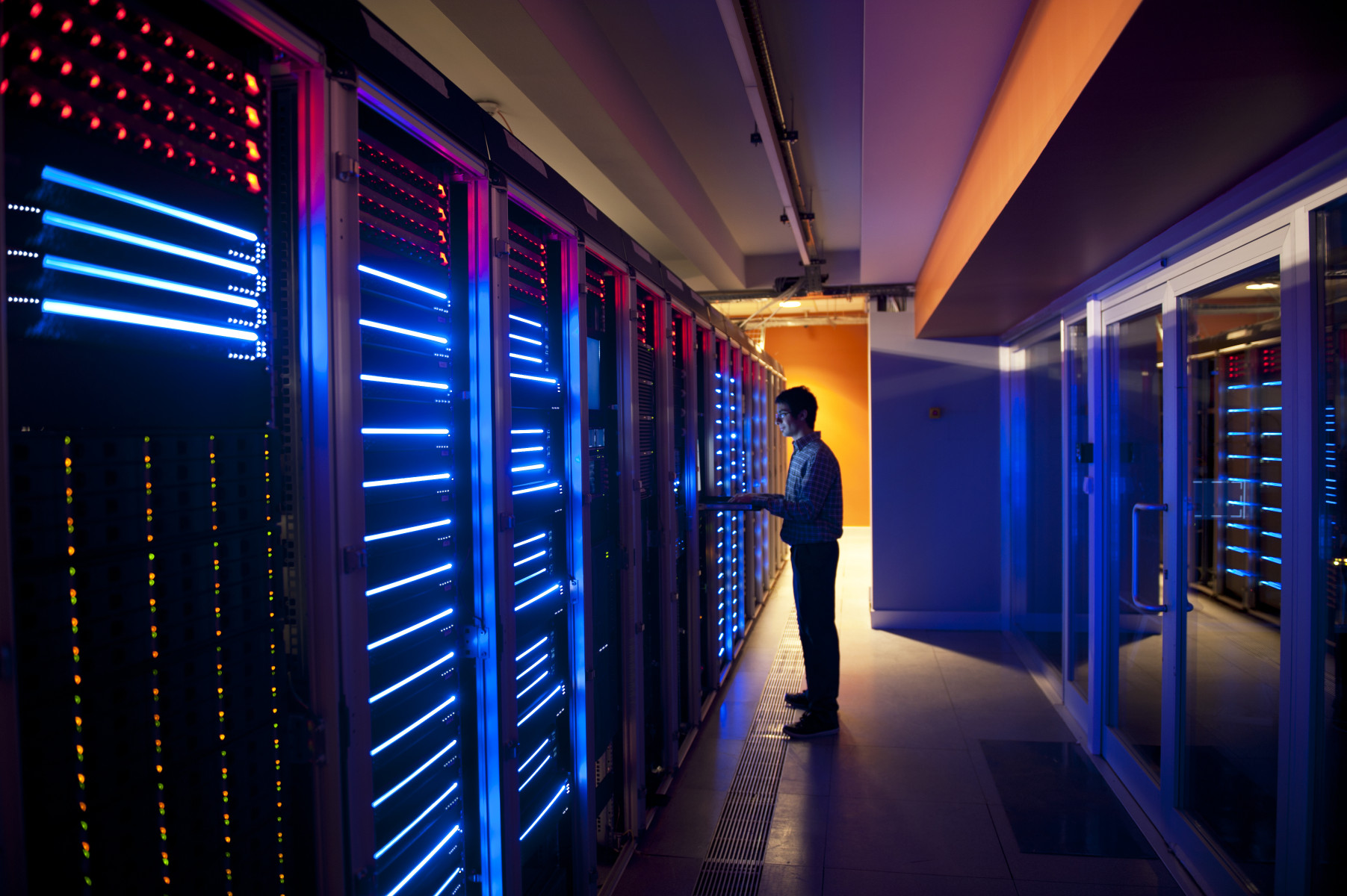 Modern interior of server room in datacenter. IT Engineer in Action Configuring Servers