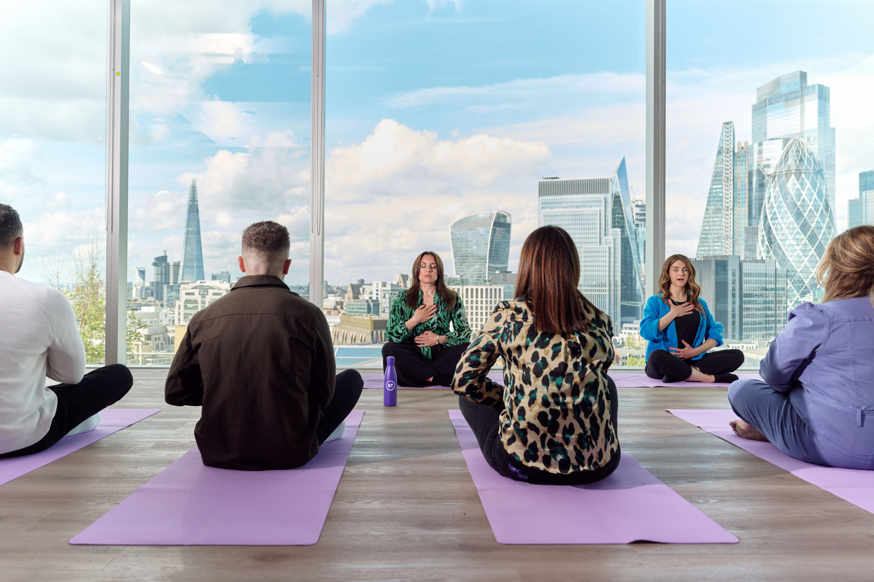 Group of colleagues meditating in office