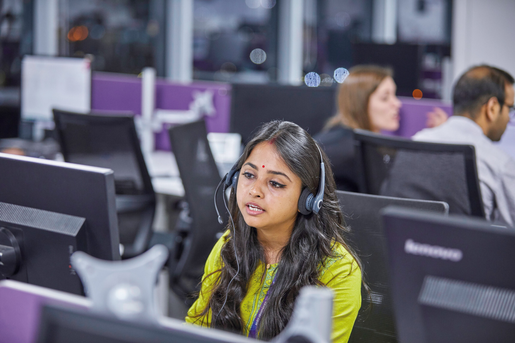 Customer service advisor wearing a headset and dealing with a query