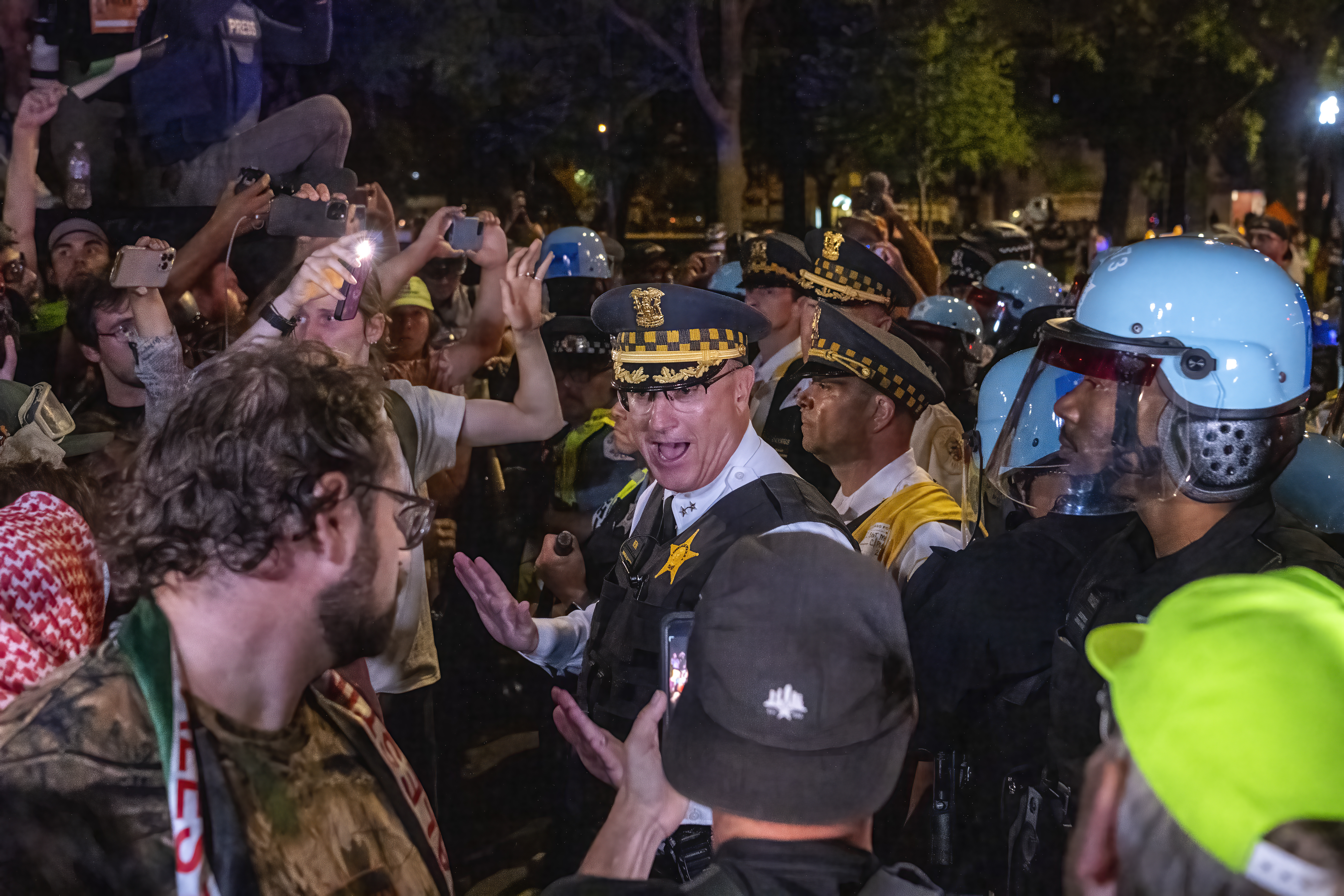 A Chicago police supervisor calms protesters and cops after a small scuffle near Union Park on the last day of the Democratic National Convention.