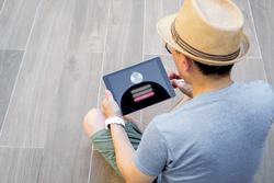 Login interface on touch screen and information security technology in cyberspace. Man using digital tablet while sitting on floor outdoor