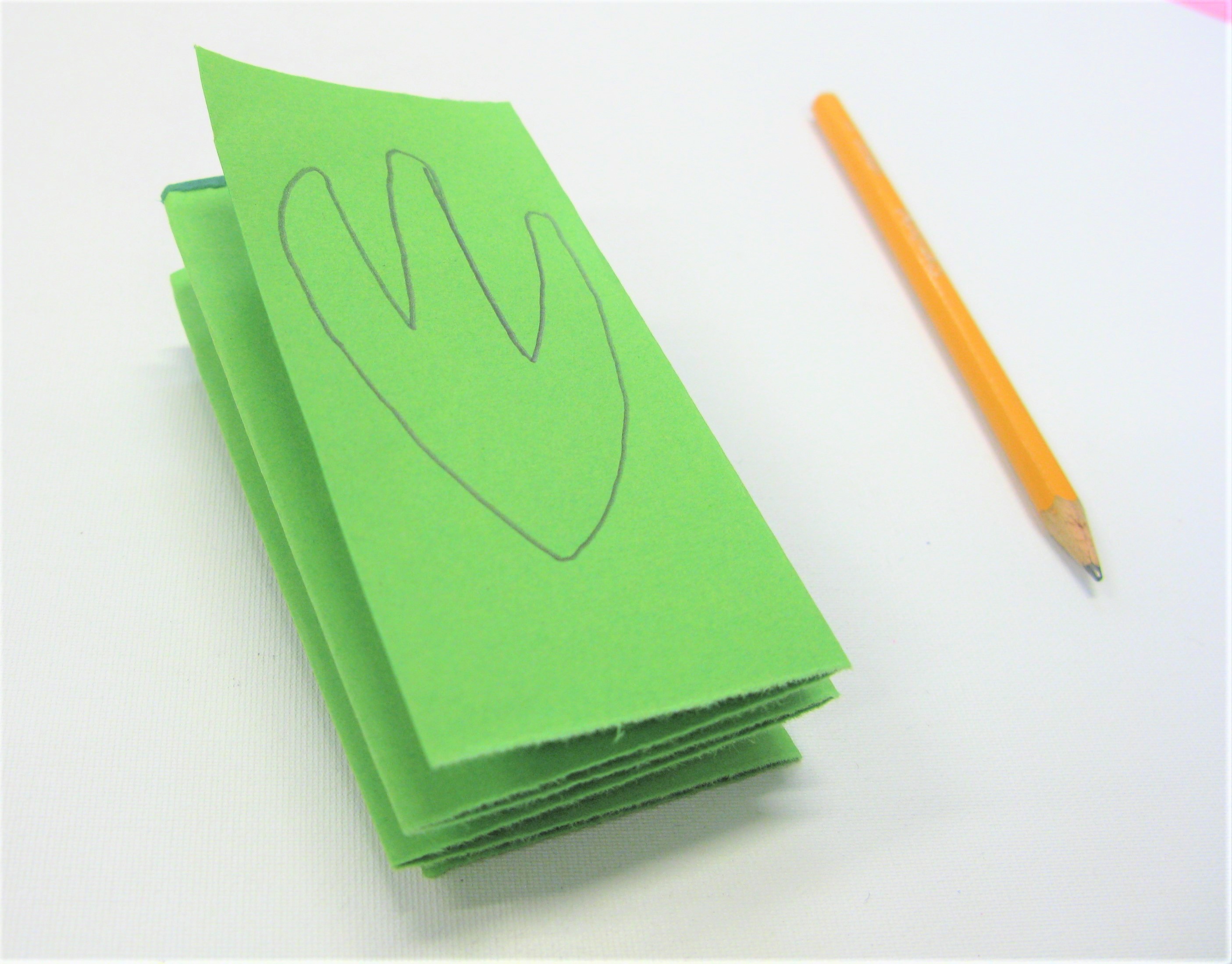 A concertina of paper with a shape drawn on the top layer