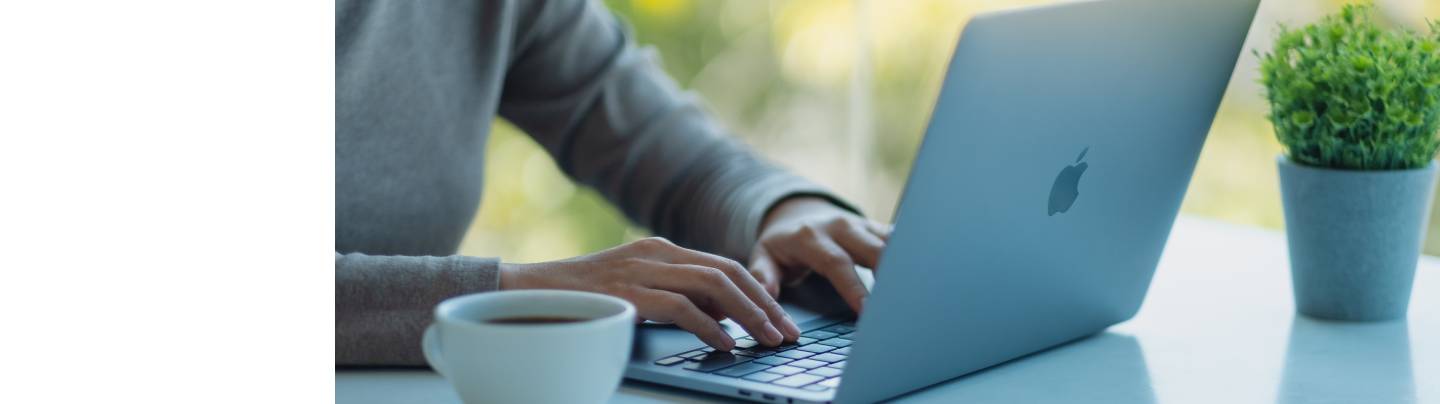 man working at mac laptop with coffee