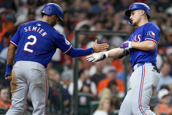 Texas Rangers' Corey Seager, right, celebrates after his two-run home run with Marcus Semien during the sixth inning of a baseball game against the Houston Astros, Friday, July 12, 2024, in Houston. (AP Photo/Eric Christian Smith)