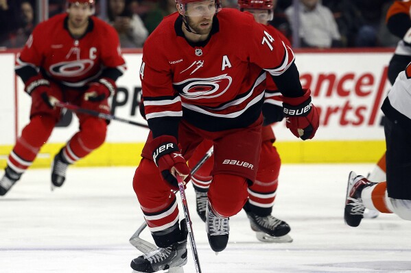 FILE - Carolina Hurricanes' Jaccob Slavin (74) chases the puck against the Philadelphia Flyers during the first period of an NHL hockey game in Raleigh, N.C., March 21, 2024. Slavin has signed an eight-year, $51.69 million contract extension with the Hurricanes. (AP Photo/Karl B DeBlaker, File)