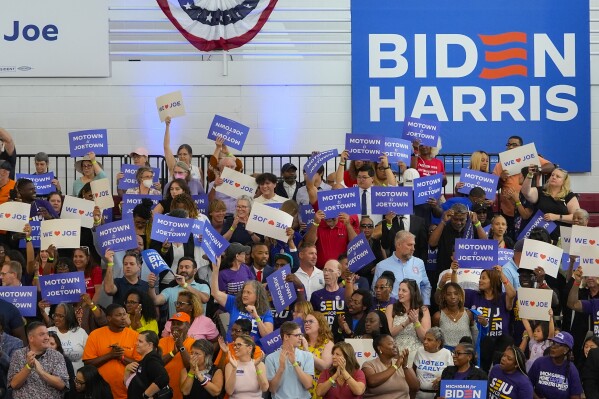 Supporters for President Joe Biden hold up signs at a campaign event as they wait for the event to begin, Friday, July 12, 2024, in Detroit. (AP Photo/Carlos Osorio)