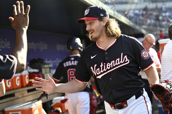 Washington Nationals relief pitcher Hunter Harvey is congratulated by teammates in the dugout after pitching the eighth inning of a baseball game against the Arizona Diamondbacks Wednesday, June 19, 2024, in Washington. (AP Photo/John McDonnell)
