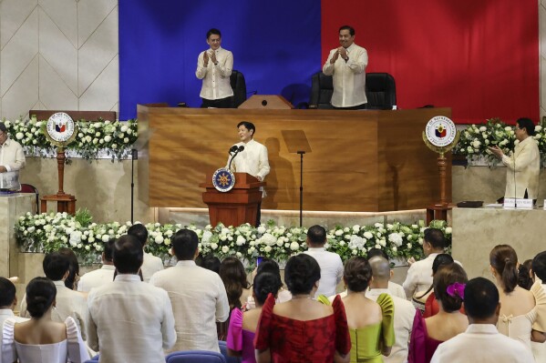 Philippines President Ferdinand Marcos Jr. center, receives a standing ovation during his third State of the Nation Address as Senate President Francis Escudero, top left and House Speaker Martin Romualdez, top right look on at the House of Representatives in Quezon City, Philippines, on Monday, July 22, 2024. (AP Photo/ Gerard V. Carreon)