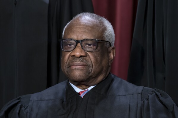 FILE - Associate Justice Clarence Thomas joins other members of the Supreme Court as they pose for a group portrait in Washington, Oct. 7, 2022. The Democratic chairman of the Senate Finance Committee said Monday, Aug. 5, 2024, that Thomas failed to publicly disclose additional travel on GOP megadonor Harlan Crow's private jet. Senator Ron Wyden of Oregon wrote to Crow's lawyer asking about the trip. Wyden is backing an election-year push to tighten the high court's ethics rules. (AP Photo/J. Scott Applewhite, File)