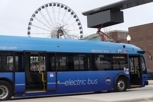 FILE - A Chicago Transit Authority electric bus charges at Navy Pier Tuesday, Feb. 14, 2023, in Chicago. The Biden administration is awarding nearly $2 billion in grants to help restart or expand electric vehicle manufacturing and assembly sites in eight states, including the presidential battlegrounds of Michigan, Pennsylvania and Georgia. Grants totaling $1.7 billion will be issued by the Energy Department to create or retain thousands of union jobs and support auto-based communities that have long driven the U.S. economy, the White House said Thursday, July 11, 2024. (AP Photo/Erin Hooley, File)