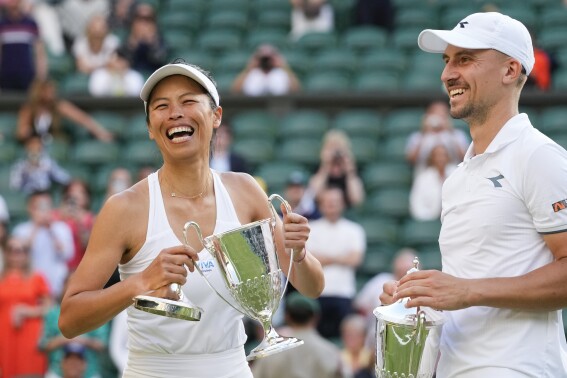 Taiwan's Su-Wei Hsieh and Poland's Jan Zielinski react with their trophy's after defeating Mexico's Santiago Gonzalez and compatriot Giuliana Olmos in the mixed doubles final at the Wimbledon tennis championships in London, Sunday, July 14, 2024. (AP Photo/Kirsty Wigglesworth)