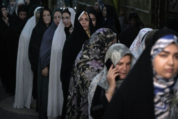Women line up to vote for the presidential election in a polling station at the shrine of Saint Saleh in northern Tehran, Iran, Friday, July 5, 2024. Iran held a runoff presidential election on Friday that pitted a hard-line former nuclear negotiator against a reformist lawmaker. (AP Photo/Vahid Salemi)