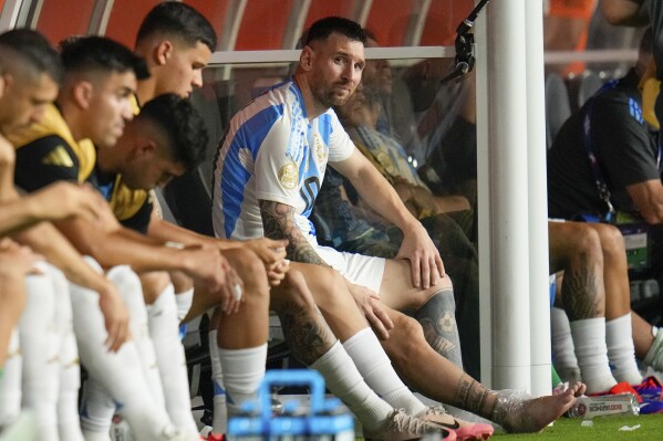 Argentina's Lionel Messi sits on the bench after leaving the field injured during the Copa America final soccer match against Colombia in Miami Gardens, Fla., Sunday, July 14, 2024. (AP Photo/Julio Cortez)