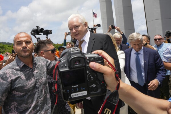 WikiLeaks founder Julian Assange, centre, is escorted to a vehicle as he leaves the federal court in Saipan, Mariana Islands, Wednesday, June 26 2024. (AP Photo/Eugene Hoshiko)